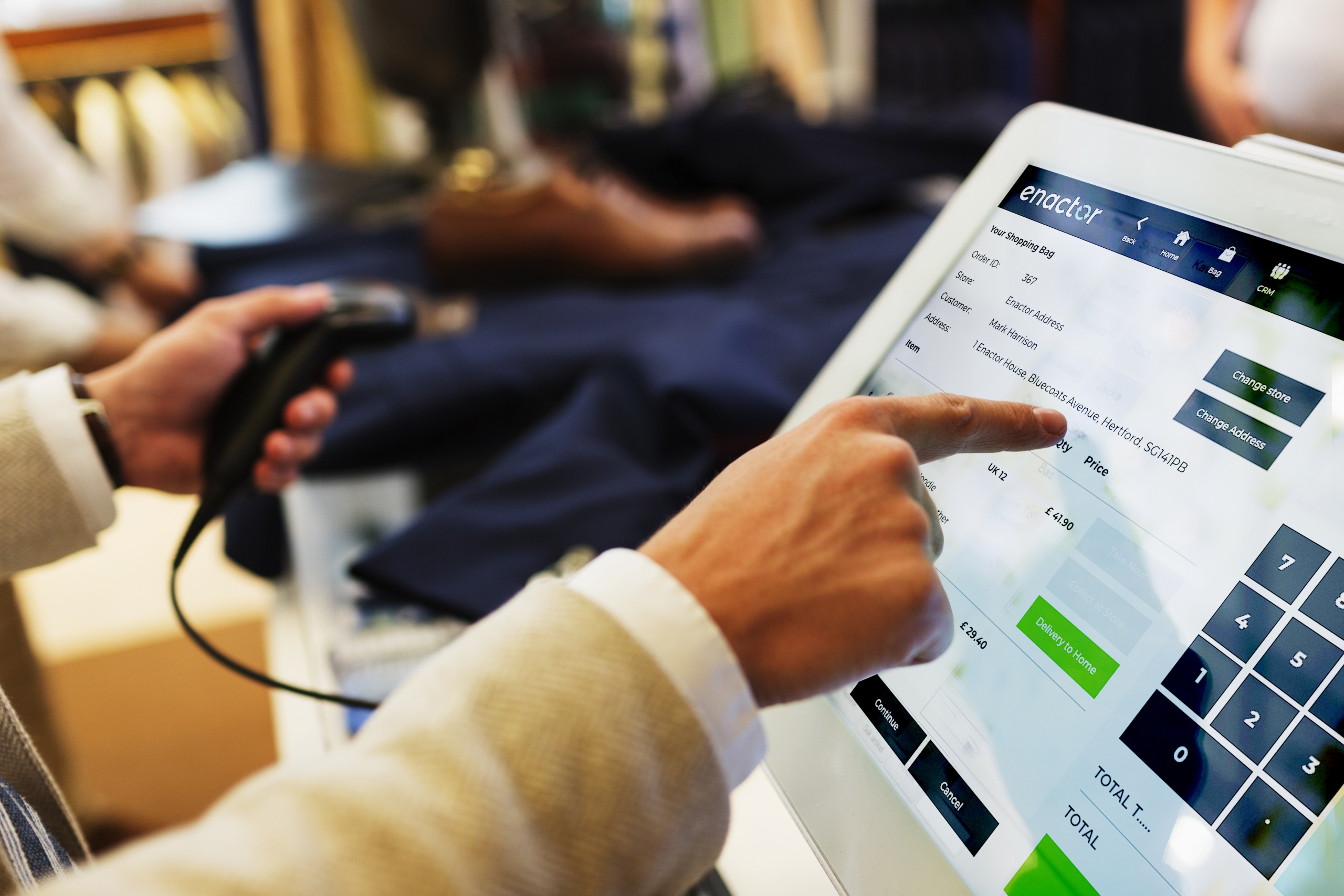 Cashier pointing on computer monitor in clothing showroom